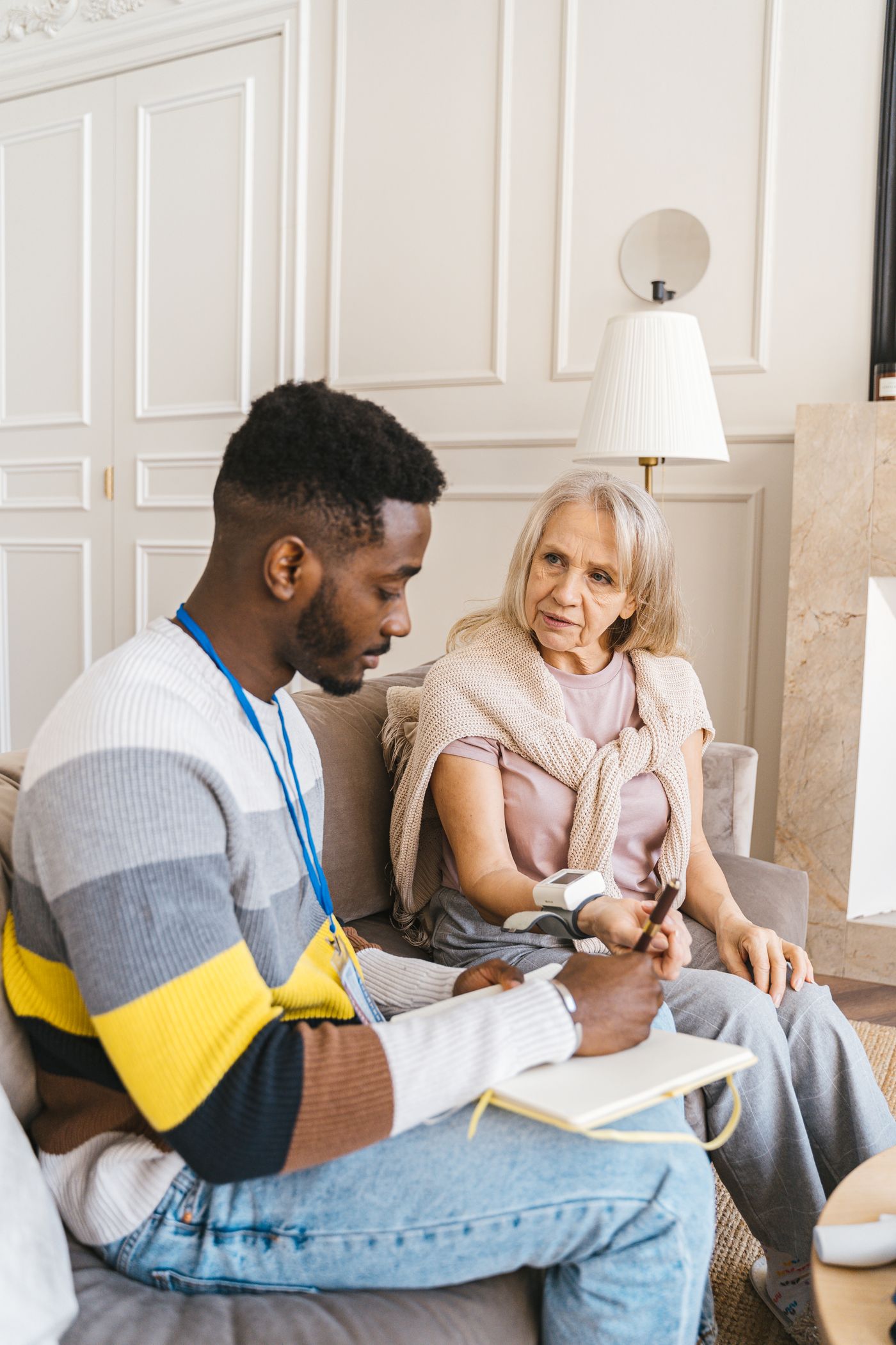 A caregiver listening closely to an older adult at home